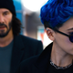 Bugs, with bright blue hair and wearing sunglasses, stands in front of Neo in The Matrix Resurrections.